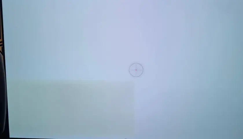 Helles Display mit sichtbaren grünen Schlieren links, ein Zeichen für OLED Burn-in. Ein Fadenkreuz-Symbol ist in der Mitte zu sehen.