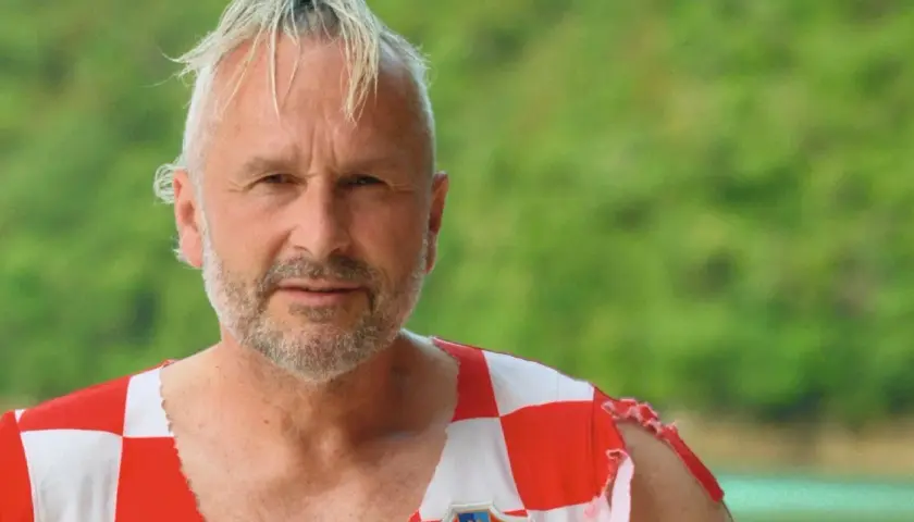 Fabian Turkalj, en man med grått hår och skägg, bär en sliten tröja med Kroatiens flagga.
