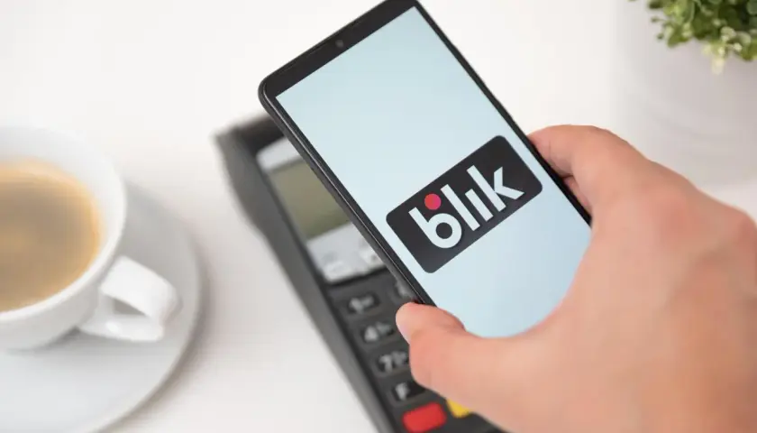 Zbliżeniowa płatność telefonem z logo Blik. Kawa czeka, a transakcja przebiega błyskawicznie.