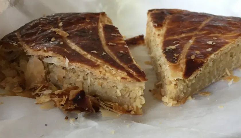 Deux parts de galette des rois coco, avec leur feuilletage doré et leur garniture généreuse, prêtes à être dégustées.
