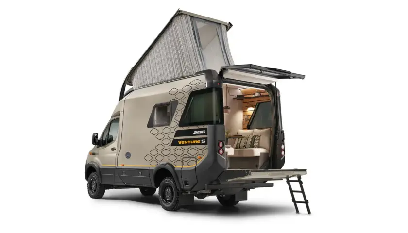 Hymer Venture S z podniesionym dachem i otwartym tyłem, ukazujący przytulne wnętrze z kanapą i poduszkami.