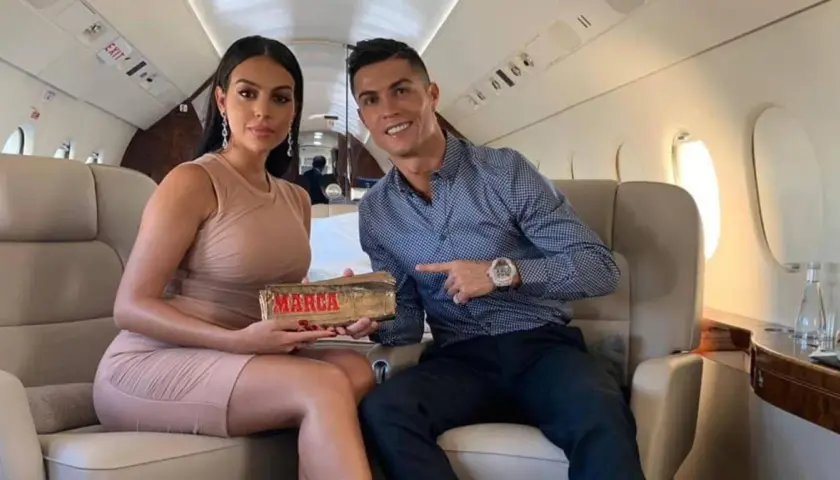 Georgina Rodriguez i Cristiano Ronaldo w prywatnym samolocie. Ona trzyma nagrodę "Marca", on wskazuje na nią.