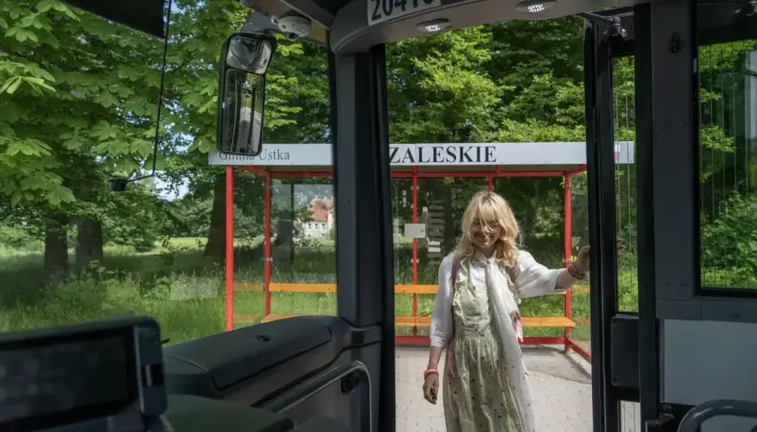 Dziewczyna wysiada z autobusu na przystanku Gmina Ustka. Słupsk i Ustka to miejsca, które warto odwiedzić.
