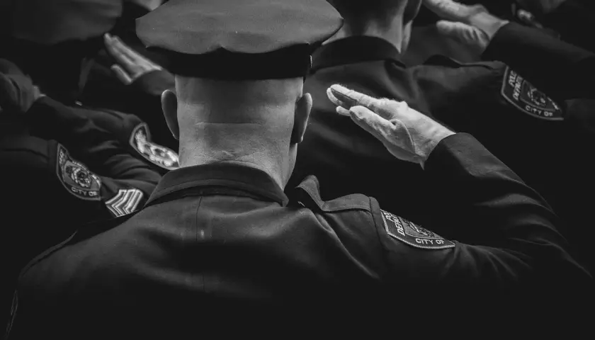 Policjanci w mundurach salutują. Dbanie o czystość munduru, jak prać mundur wojskowy, to ważny element służby.