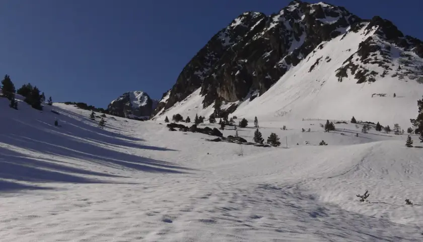 Paisaje invernal en Grau Roig, con montañas nevadas y cielo azul intenso.