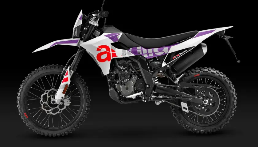 Aprilia RX 125, una moto de cross blanca con detalles morados y rojos. ¡Ideal para tus aventuras off-road!