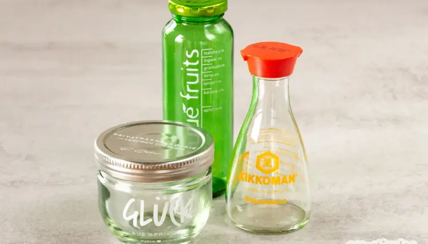 Glasflaschen mit Etiketten: "true fruits" Getränk, "Glück" Marmelade und Kikkoman Sojasauce. Anleitung zum true fruits flaschen schrift entfernen.