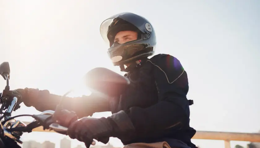 Giovane con casco integrale, pronto a partire in motorino. L'obbligo casco motorino è fondamentale per la sicurezza.