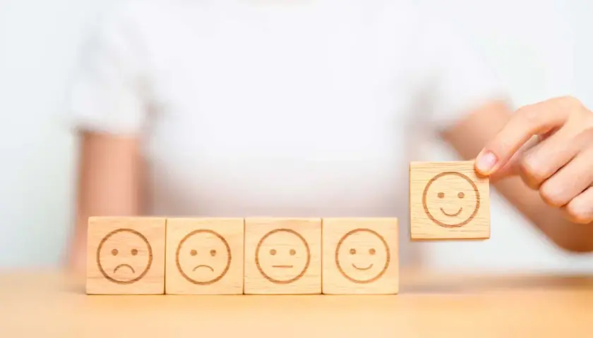 Una persona che se la prende subito, scegliendo un cubo con un sorriso tra faccine tristi e neutre.