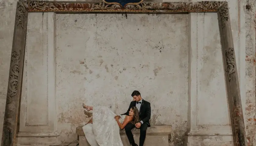 Para młoda w stylizowanych strojach na tle zabytkowych murów. Zastanawiasz się, ile kosztują zdjęcia u fotografa?