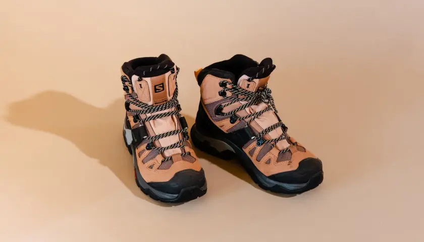 A pair of tan Salomon hiking boots with black accents and laces. These boots are designed for rugged terrain, but how much do hiking boots weigh?