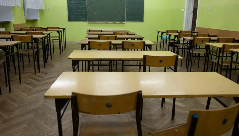 Puste ławki w sali lekcyjnej, czekające na powrót uczniów do szkoły po świętach wielkanocnych.