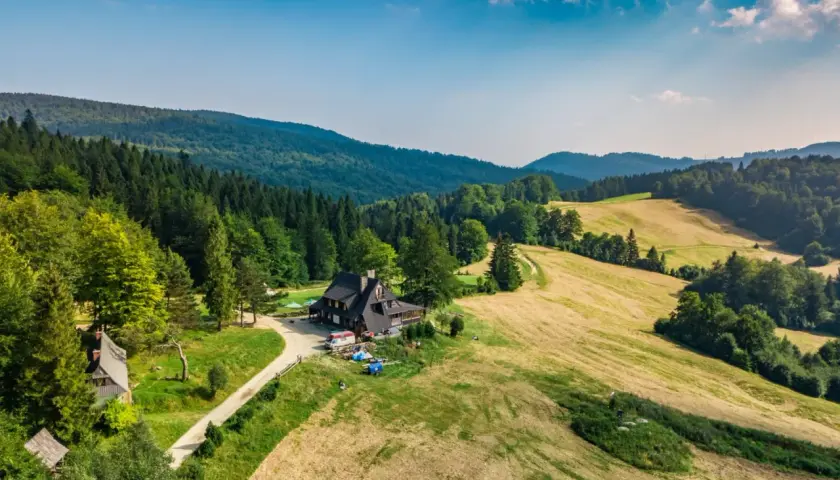 Malownicza bacówka nad Wierchomlą, gdzie trasa turystyczna prowadzi przez zielone wzgórza i lasy.