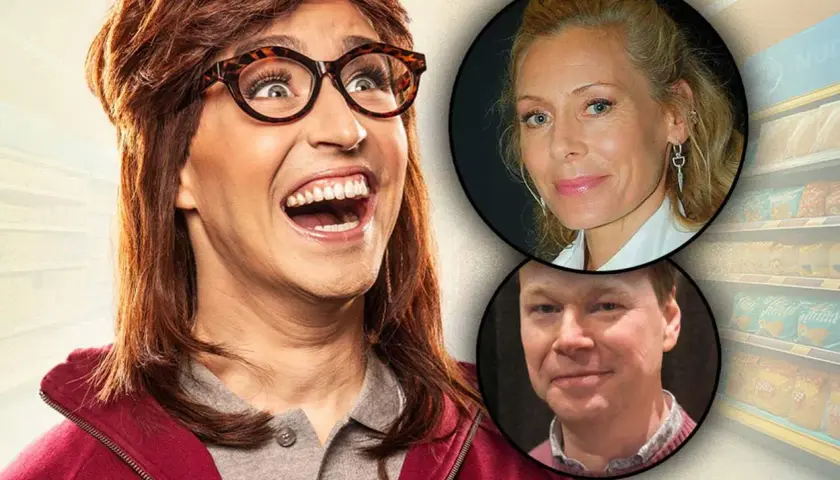 Terese i kassan, en skådespelare med peruk och glasögon, skrattar högt. Bredvid henne syns porträtt av en kvinna och en man.