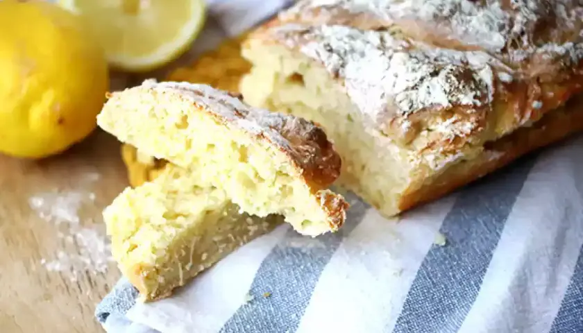 Pain de mie levure chimique, doré et saupoudré de farine, avec des citrons frais à côté.