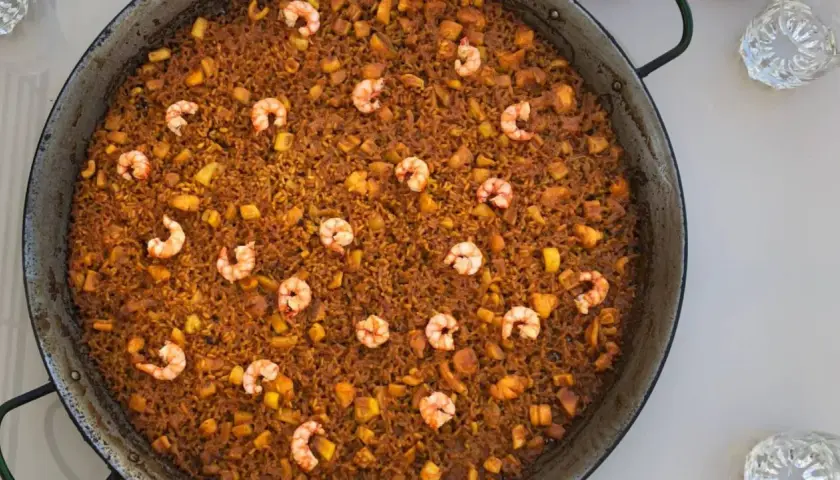Arroz del senyoret en paellera, con gambas, trozos de calamar y patata. Un plato generoso y lleno de sabor.