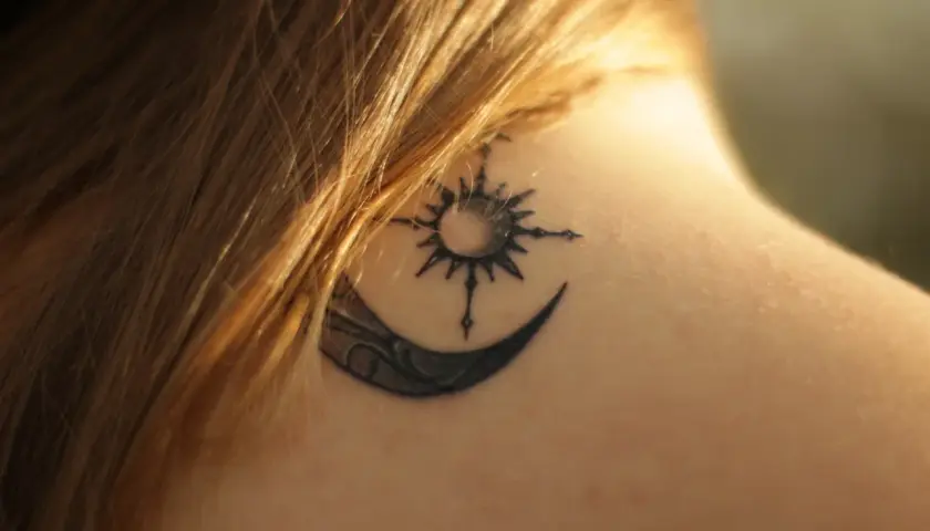 Tatouage lune et soleil sur la nuque, en phase de cicatrisation, une légère croûte est visible.