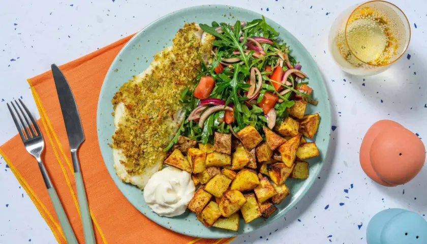 En tallrik med panerad torsk, krispiga potatisbitar, en fräsch sallad och en klick majonnäs. Ett perfekt torsk recept för en god middag.