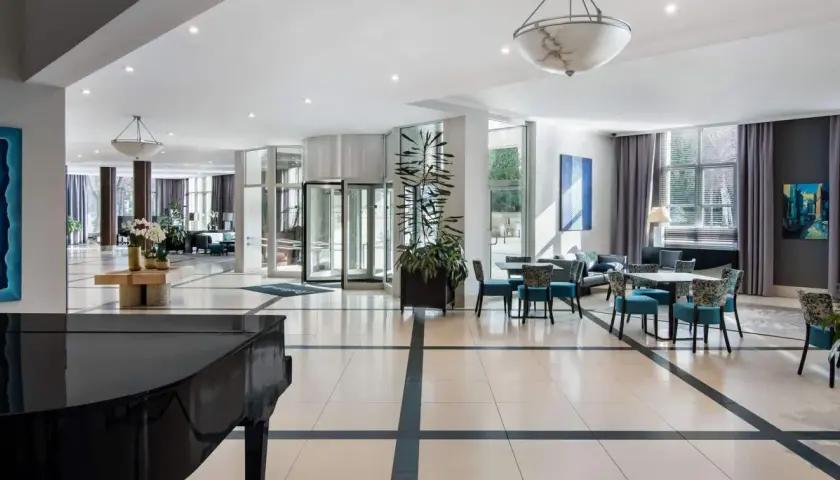 Eleganckie wnętrze hotelu Radisson Blu Wrocław z fortepianem, wygodnymi fotelami i stolikami.