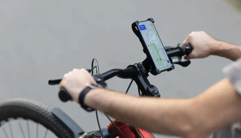 Rowerzysta z telefonem na kierownicy, nawigacja pokazuje trasę. Idealne do śledzenia treningów z Endomondo.