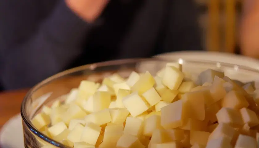 Un bol rempli de dés de fromage savoyard, prêt à être fondu pour un plat réconfortant.