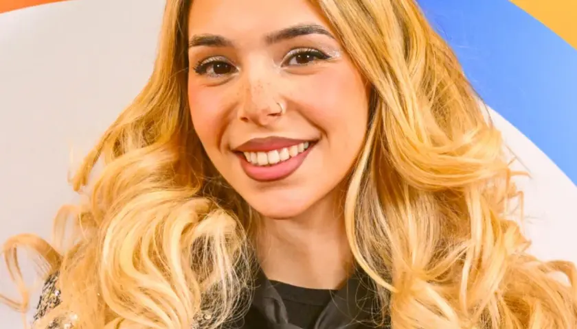 Uśmiechnięta młoda kobieta z blond włosami i piegami.