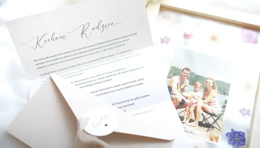 Otwarta kartka z napisem "Kochani Rodzice" i tekstem podziękowania. Obok zdjęcie uśmiechniętej rodziny. To piękny przykład podziękowania.