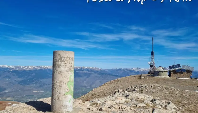 Cima de Tosa d'Alp, 2578m. Pilar de hormigón y antena de telecomunicaciones en un día soleado con vistas a montañas nevadas.