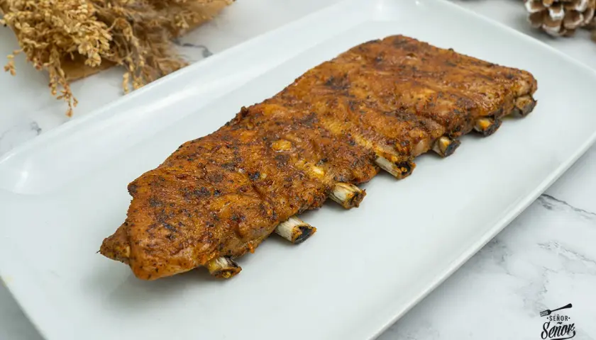 Costilla de cerdo al horno, jugosa y dorada, lista para disfrutar. Un manjar que invita a saborear cada bocado.