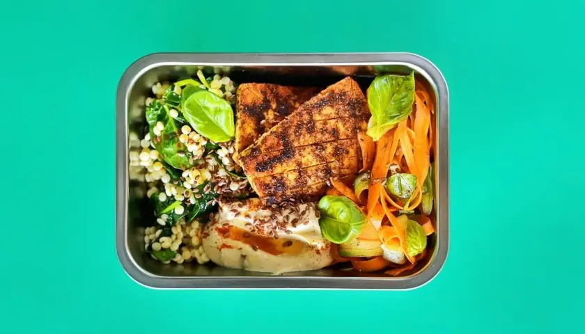 Pyszna dieta pudełkowa wegetariańska Warszawa: grillowany tofu, kasza, szpinak, marchewka i hummus.