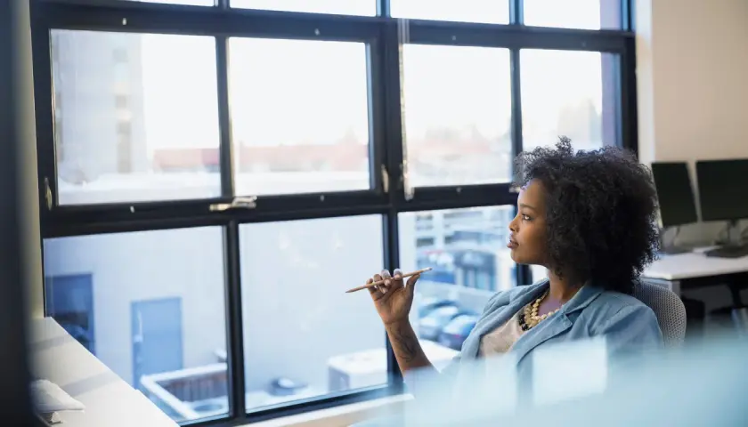 A woman ponders her future, perhaps considering a public administration degree to shape policy and improve communities.