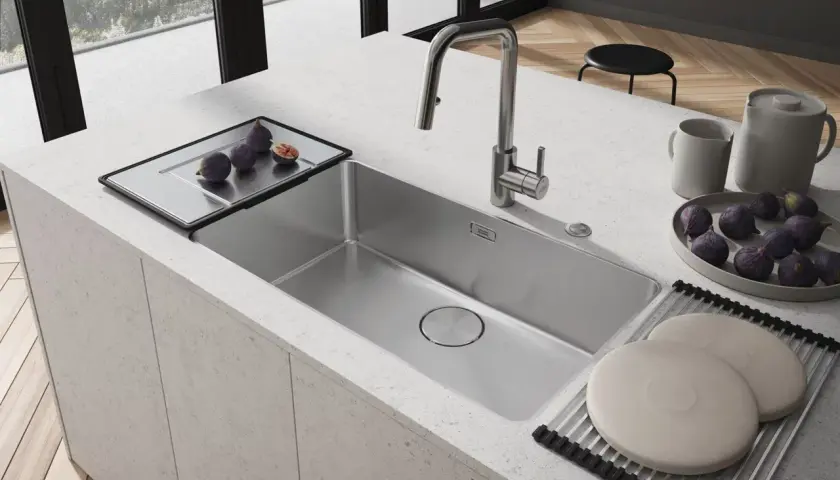 Nowoczesny zlew kuchenny ze stali nierdzewnej, z baterią i tacą z figami.
