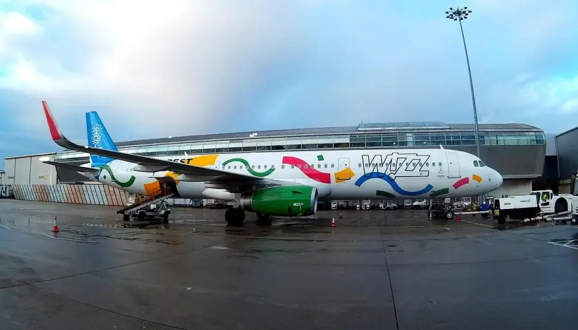 Samolot Wizz Air z kolorowym malowaniem na płycie lotniska.
