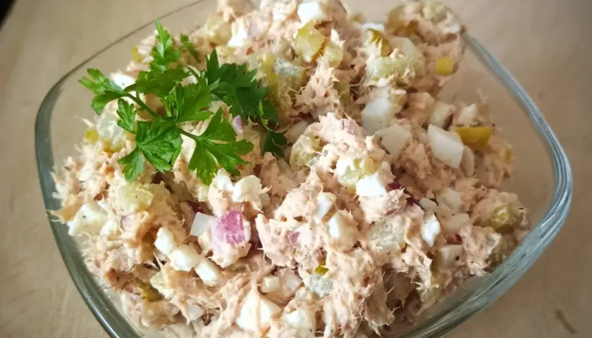 Pyszna pasta z tuńczyka i jajka, z dodatkiem ogórka kiszonego i cebuli, udekorowana natką pietruszki. Idealna na kanapki.