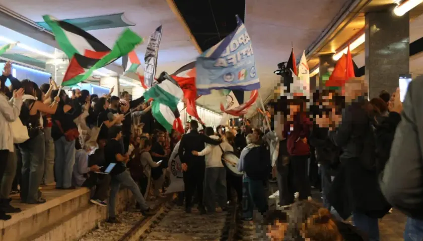 Folla in piazza a Roma per uno sciopero venerdì, sventolano bandiere palestinesi e altri vessilli.