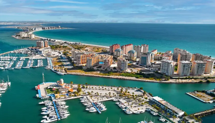 Widok na La Manga, Hiszpania: luksusowe apartamenty i pełen jachtów port nad turkusowym morzem.