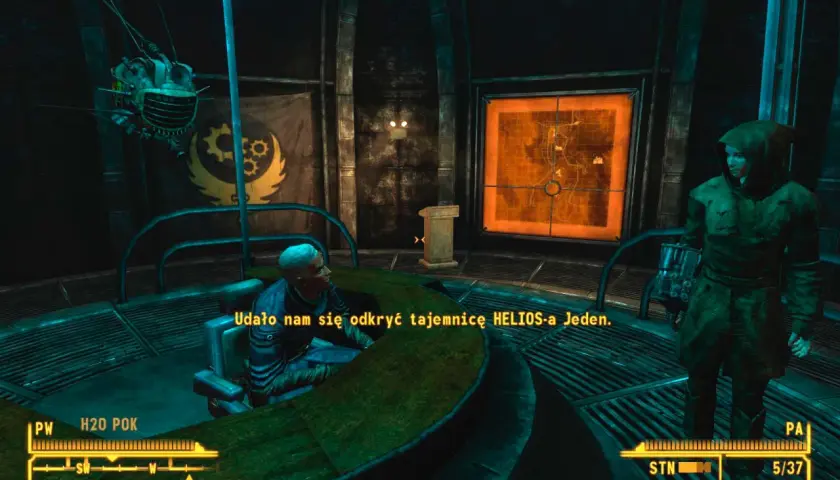 Postać w kapturze stoi obok mapy w grze Fallout: New Vegas PCR. Mężczyzna przy stole mówi: "Udało nam się odkryć tajemnicę HELIOS-a Jeden.