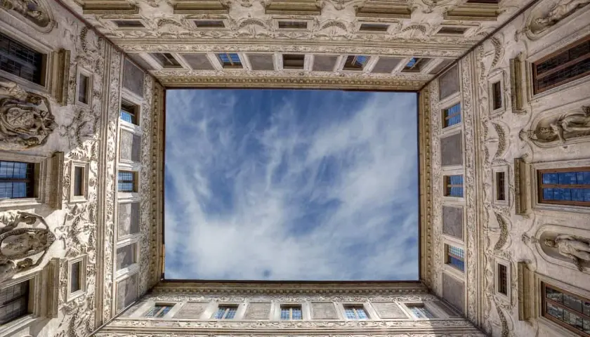 La galleria Borromini, con la sua prospettiva unica, incornicia un cielo azzurro e nuvoloso.