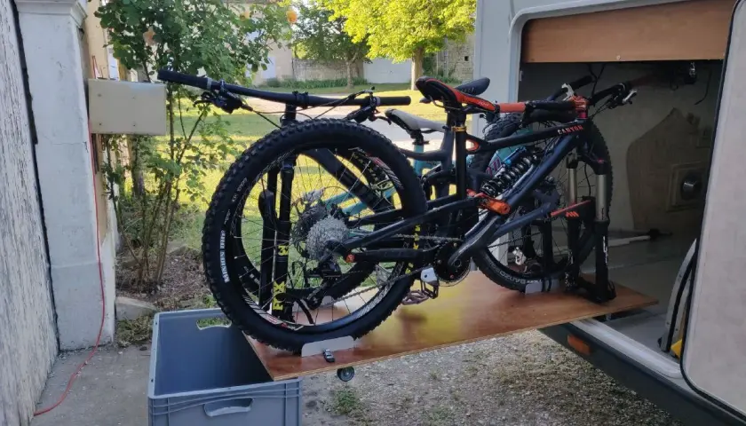 Plateforme DIY pour fabriquer un porte vélo de soute, avec deux VTT prêts à être rangés.