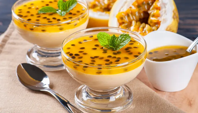 Douceur tropicale : deux coupes de mousse onctueuse, garnies de fruits de la passion et de menthe, un délice de dessert brésilien.