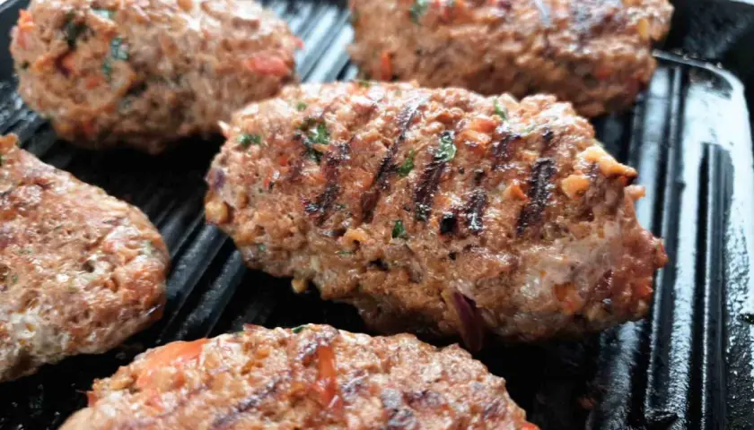 Soczyste Adana kebab w trakcie grillowania. Idealny przepis na pyszny obiad.