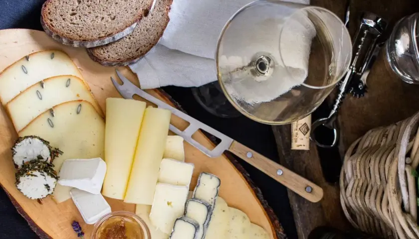 Deska serów z chlebem i kieliszkiem wina, idealna do degustacji Bardolino Chiaretto.