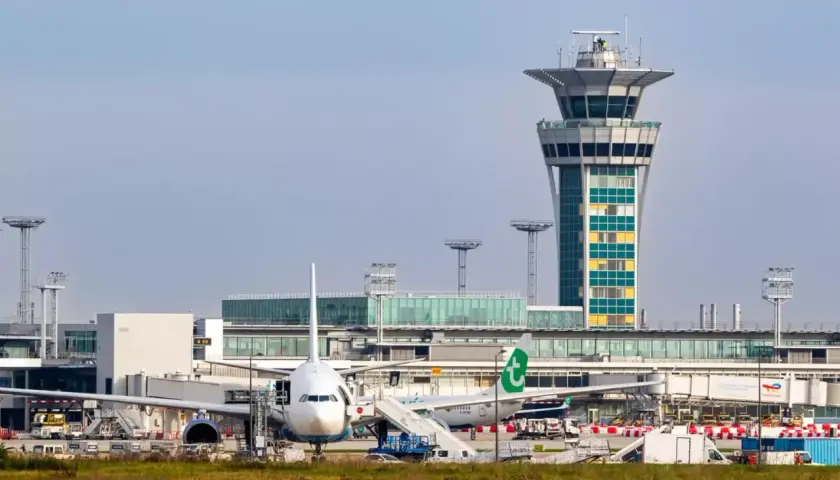 Paryż lotnisko Orly: samoloty czekają na pasażerów, a wieża kontroli lotów czuwa nad ruchem. Dojazd do centrum jest łatwy.