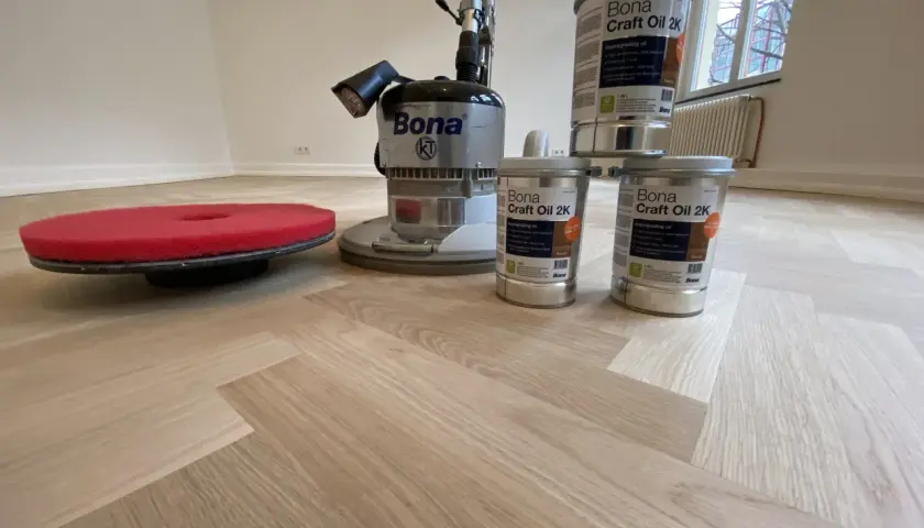 Bona Poliermaschine und Ölbehälter bereit, um das Parkett zu versiegeln.