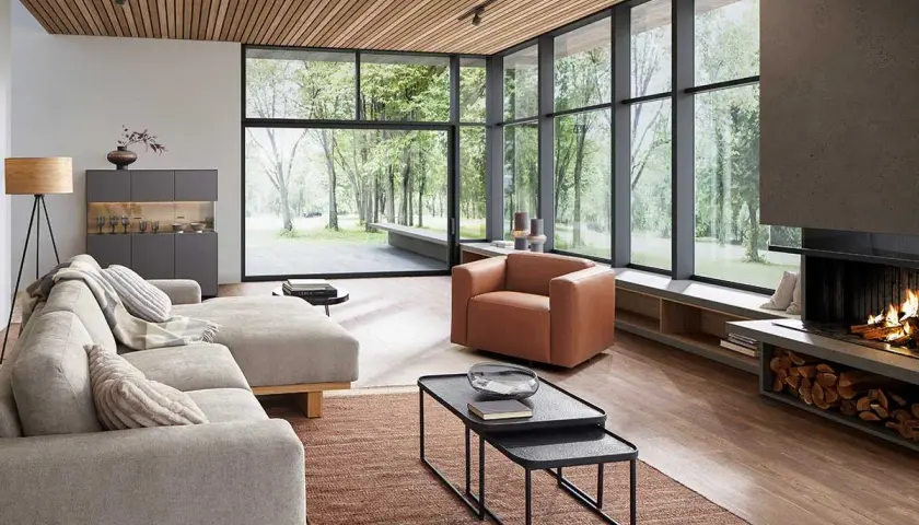 Modernes Wohnzimmer mit großem Fenster, Kamin und bequemer Couch. Tolle Einrichtungstipps für ein stilvolles Zuhause.