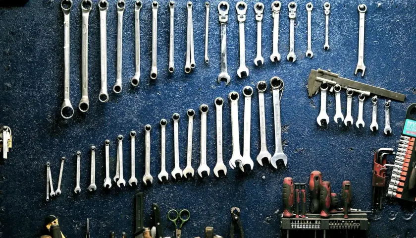 Un mur de garage bleu orné de clés à molette et d'outils divers, rappelant le droit de rétention du garage.