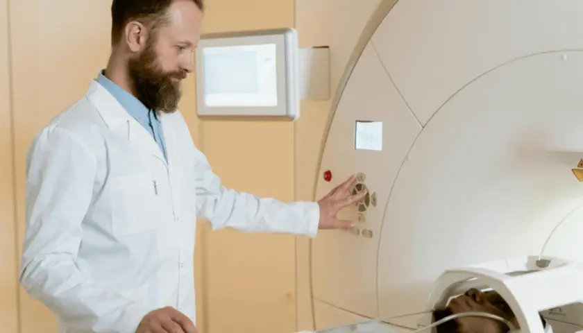 Technik elektroradiolog zarobki: specjalista obsługuje aparat MRI, dbając o pacjenta i badanie.