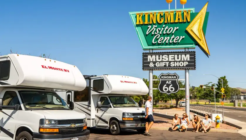 Dwa kampery El Monte RV przy znaku Kingman Visitor Center na Route 66.