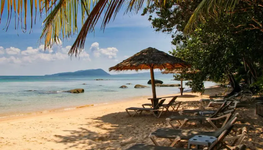 Sonniger Strand in Kambodscha, ein echter Geheimtipp. Liegestühle und Sonnenschirme laden zum Entspannen ein.