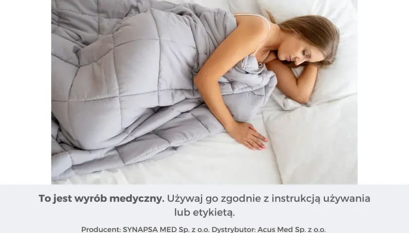 Kobieta śpi pod szarą kołdrą obciążeniową. Dowiedz się, jak dobrać idealną kołdrę obciążeniową dla siebie.